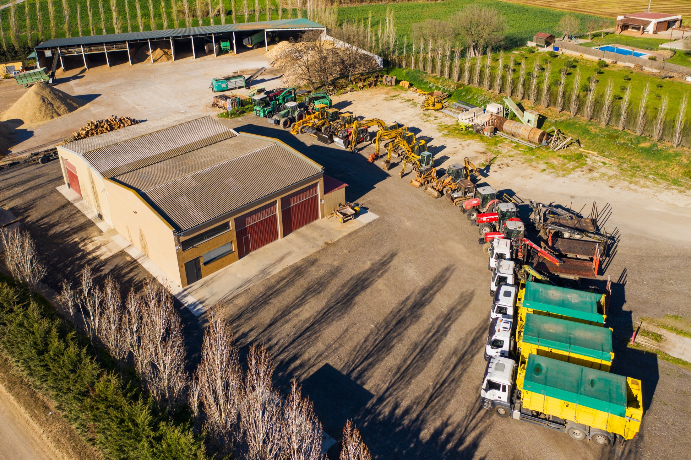 Nau agrícola amb tractors i maquinària vista des de l’aire